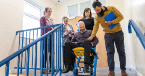 Personal Emergency Evacuation Plan (PEEP) in action – staff assisting wheelchair user during fire evacuation.